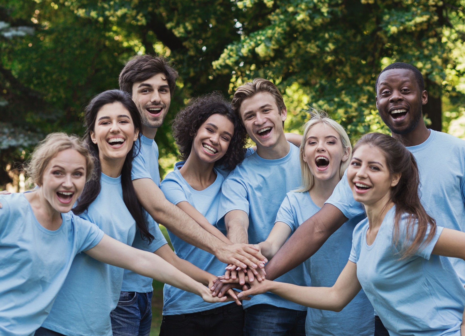 Young happy volunteers outdoor meeting at park